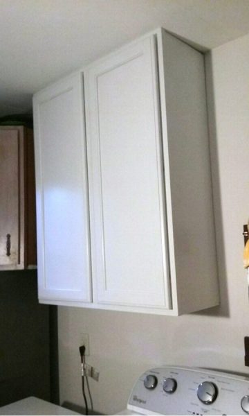 The large cabinet is hung all the way to the ceiling. 